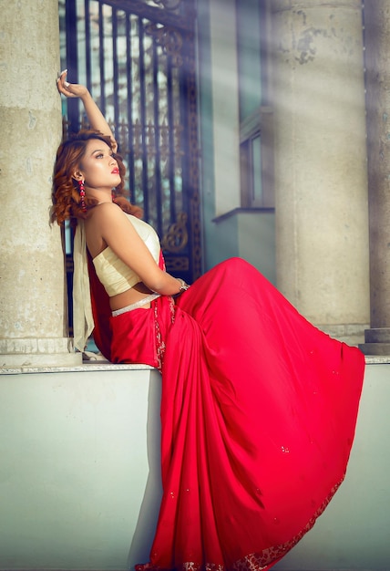 Hermosa dama asiática sexy con sari rojo con modo sensual