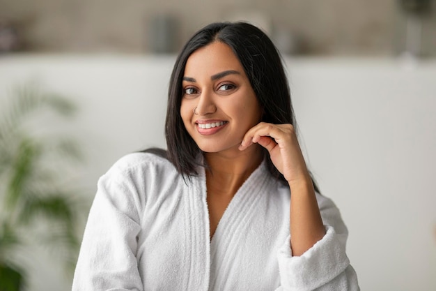 Hermosa dama india con maquillaje natural posando en el baño