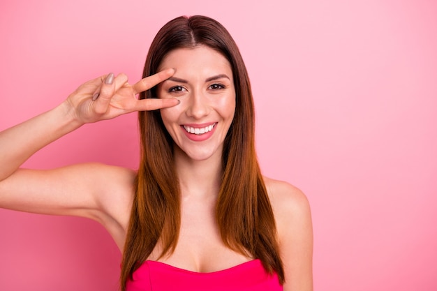 Foto hermosa dama posando contra la pared rosa