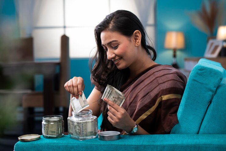 Foto una hermosa dama en sari poniendo sus ahorros en un frasco de vidrio