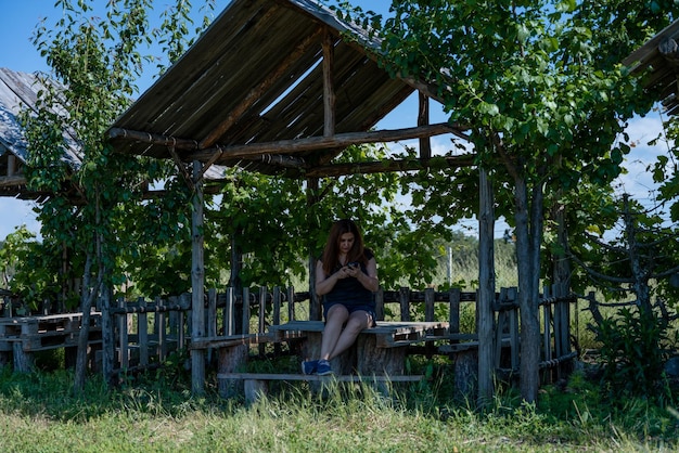 Una hermosa dama trabajando en el teléfono en las chozas de pérgola en el campo de lavanda