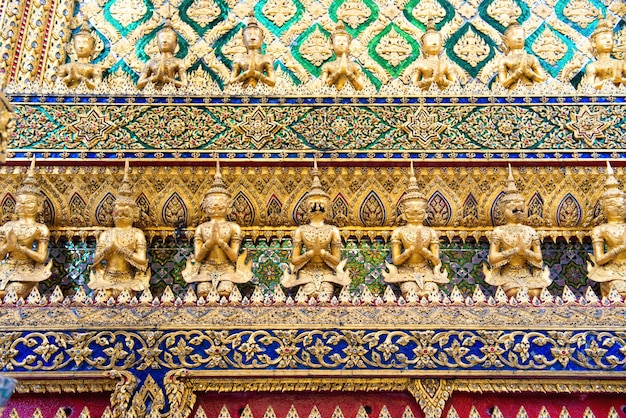 Hermosa decoración de mosaico tradicional con detalles dorados y estatuas en la pared del complejo del Gran Palacio del Buda Esmeralda Bangkok Tailandia