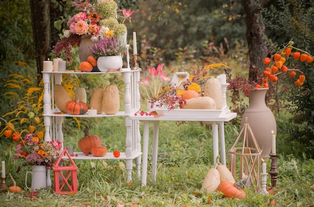 Hermosa decoración de otoño con flores, bayas, calabazas en el jardín.