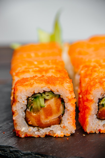 Hermosa y deliciosa variedad de rollos de sushi en un tablero de piedra.