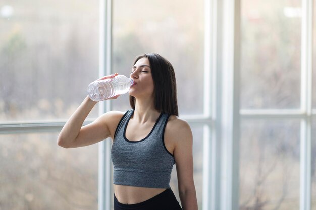 Hermosa deportista turca está bebiendo agua después de la sesión de entrenamiento