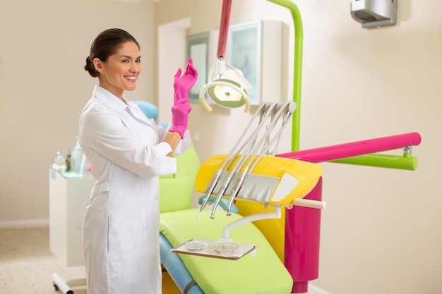 Hermosa doctora caucásica sonriente con guantes asépticos