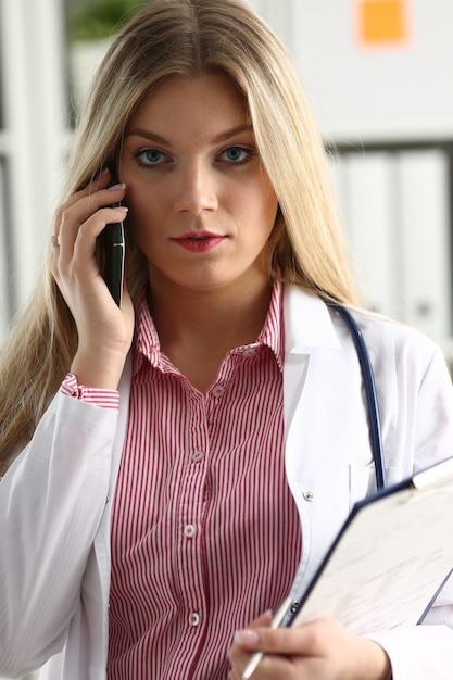 Hermosa doctora hablando por teléfono