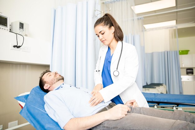 Hermosa doctora hispana examinando a un paciente en la sala de emergencias