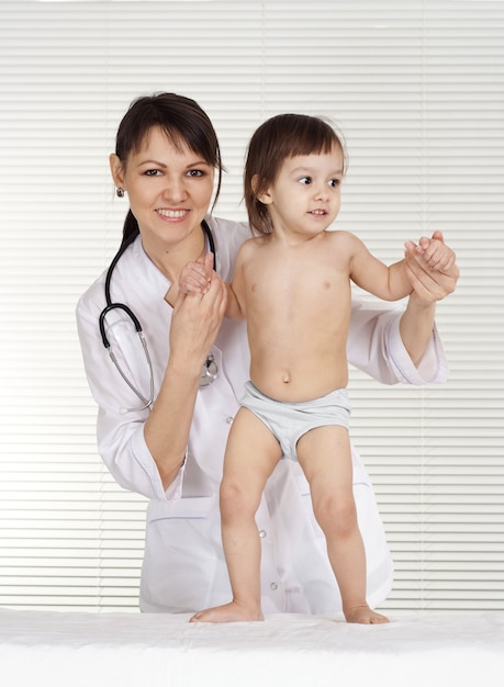 Hermosa doctora con niña en su oficina