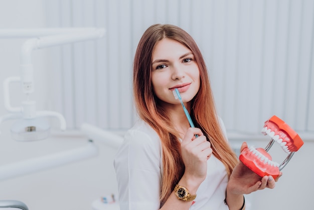 Hermosa doctora ortodoncista le muestra cómo cuidar sus dientes