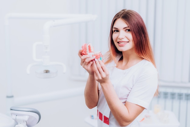 Hermosa doctora ortodoncista le muestra cómo cuidar sus dientes