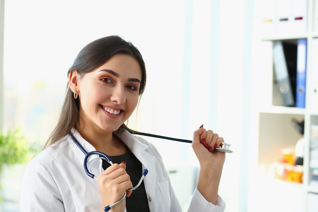 Hermosa doctora sonriente en el retrato del lugar de trabajo