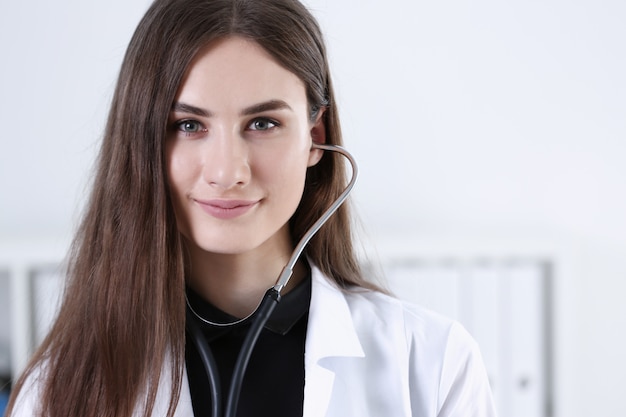 Hermosa doctora sonriente sostenga en la mano