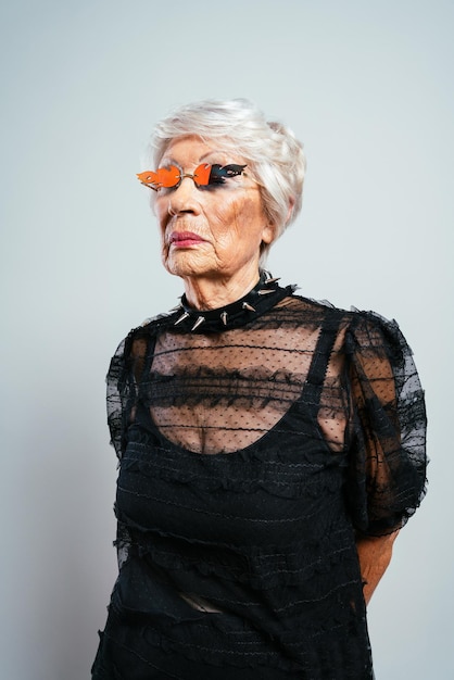 Hermosa elegante mujer influyente. abuela posando en el estudio con ropa de moda. señora mayor feliz celebrando y haciendo concepto sobre antigüedad y estilo vida | Foto Premium