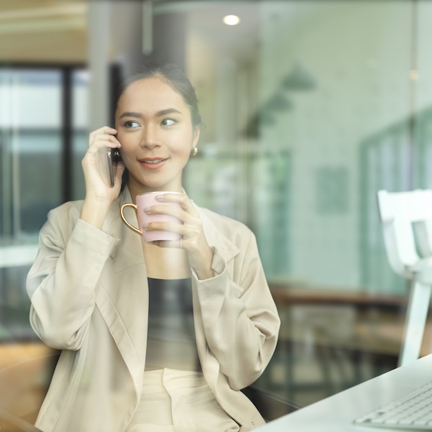 Hermosa empresaria asiática tomando un café