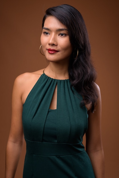 hermosa empresaria asiática en vestido verde