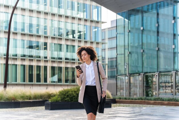 Hermosa empresaria hispana caminando al aire libre