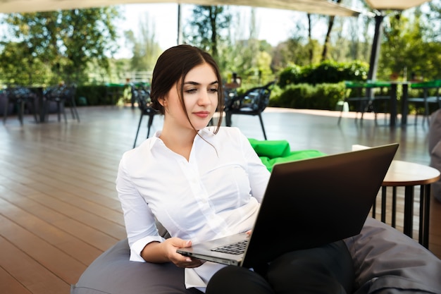 Hermosa empresaria independiente que trabaja en un café en la computadora