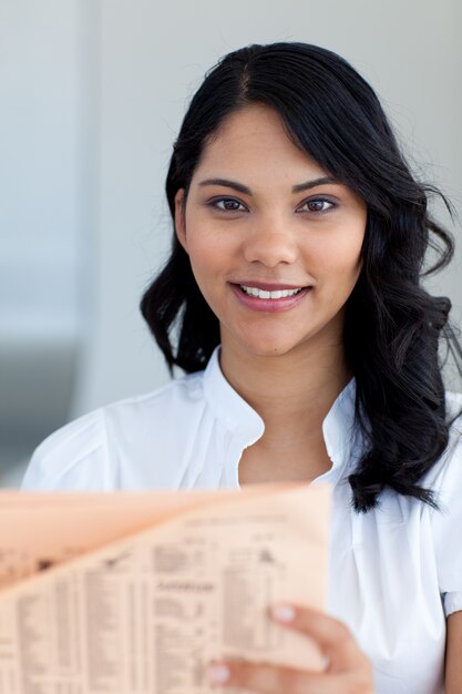 Hermosa empresaria leyendo un periódico