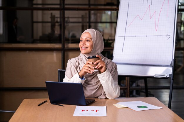 Hermosa empresaria del Medio Oriente con hijab trabajando en su oficina