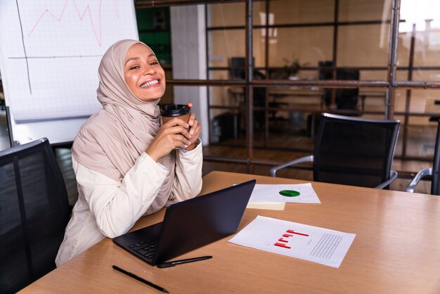 Hermosa empresaria del Medio Oriente con hijab trabajando en su oficina