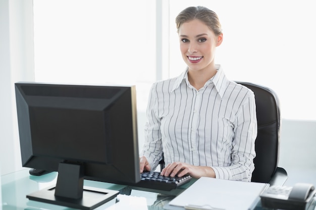 Hermosa empresaria sonriente trabajando en su computadora