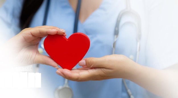 Foto hermosa enfermera sosteniendo un corazón rojo medio