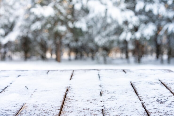 Hermosa escena de invierno. Fondo borroso de fondo nevado de naturaleza navideña, mesa de madera en bokeh brillante. Para la exhibición del producto, maqueta de Navidad.