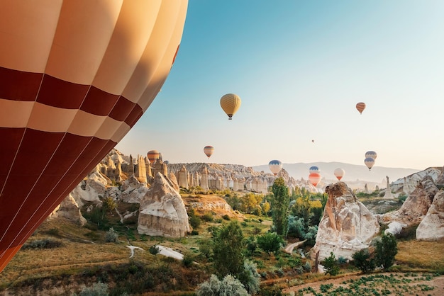 Hermosa escena matutina con globos de aire caliente volando sobre el valle del amor al amanecer