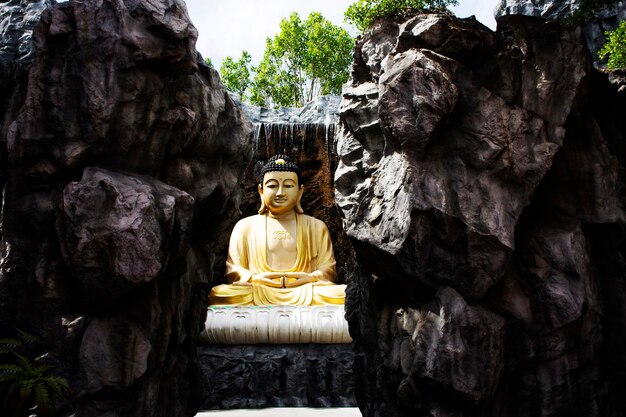 Hermosa estatua de buda amitabha en el jardín para los tailandeses que viajan visitan el respeto orando en las cascadas de la fuente de jardinería del templo Wat Laksi Rat Samosorn en la ciudad de Ban Phaeo en Samut Sakhon Tailandia