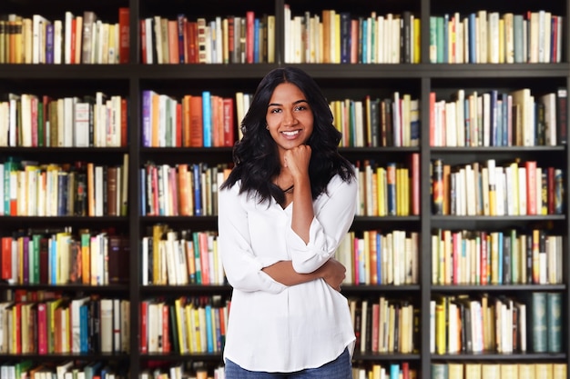 Hermosa estudiante de pie en la escuela de bibliotecas