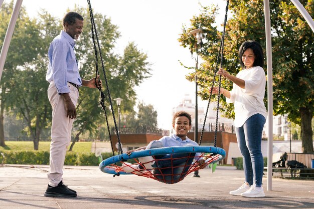 Hermosa familia afroamericana feliz unión en el parque - familia negra divirtiéndose al aire libre