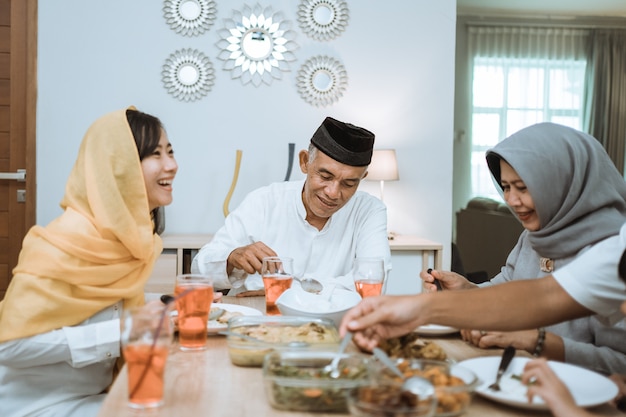 Hermosa familia asiática disfrutando de su cena iftar en casa. ramadan kareem islam romper la tradición del ayuno