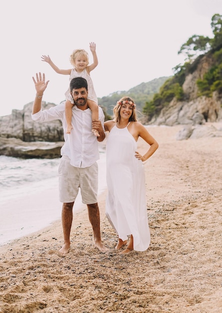 Hermosa familia caminando por una playa mediterránea