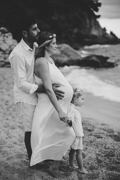 Hermosa familia caminando por una playa mediterránea