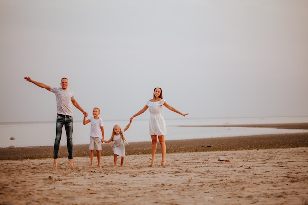 Foto una hermosa familia con dos hijos en ropa de colores claros rebota