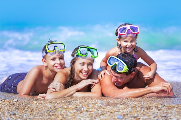 Hermosa familia encantadora en la playa de arena