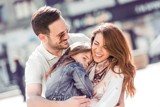 Hermosa familia feliz divirtiéndose en la ciudad