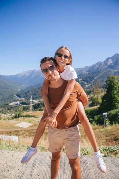 Hermosa familia feliz en las montañas al fondo