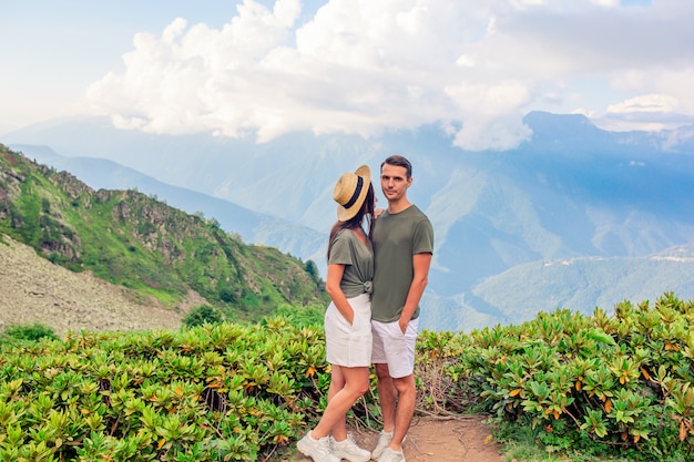 Foto hermosa familia feliz en las montañas en el fondo de niebla