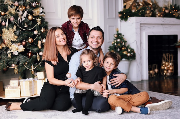 Hermosa familia grande pasar tiempo en casa cerca del árbol de Navidad