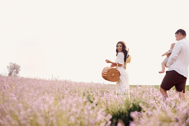 Hermosa familia joven en un campo de lavanda pasa el día