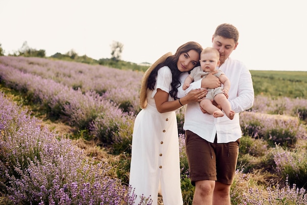 Hermosa familia joven en un campo de lavanda pasa el día