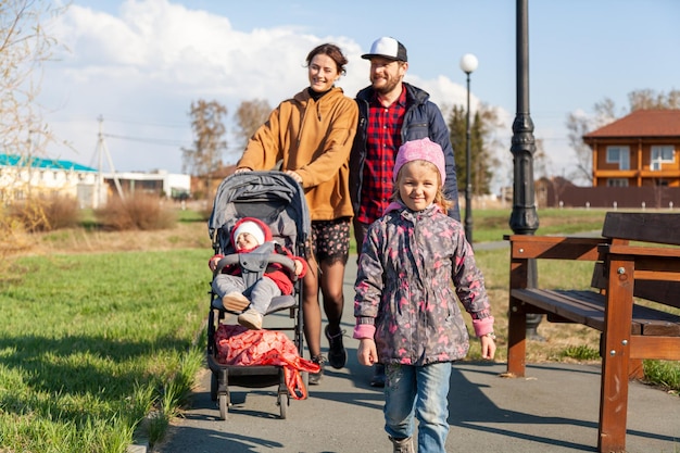 Hermosa familia joven Mamá Papá y 2 hijas caminando descansando disfrutando de la naturaleza en el parque de otoño Verano en el campo estado de ánimo de vacaciones de concepto familiar