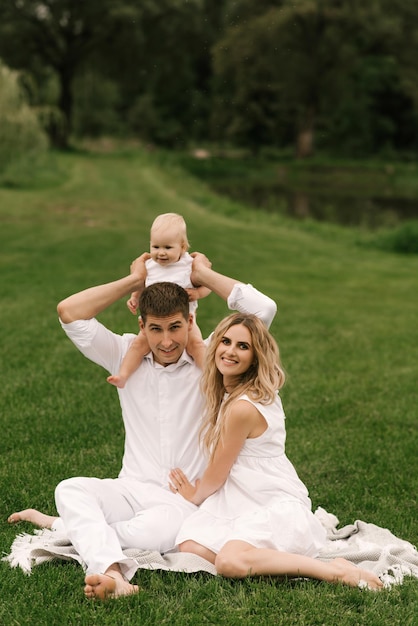 Hermosa familia joven mamá y papá con una hija de un año en la naturaleza familia feliz