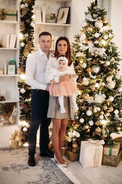 Hermosa familia con una niña en Navidad