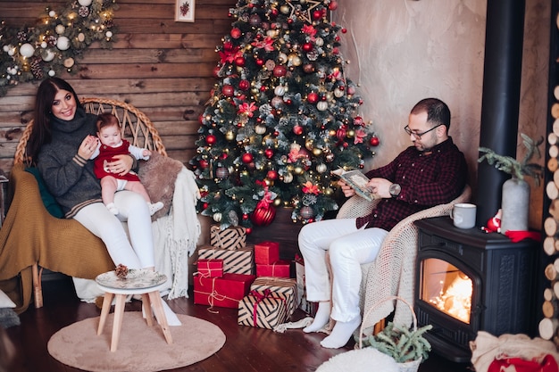 Hermosa familia con niño disfrutando juntos del ambiente navideño