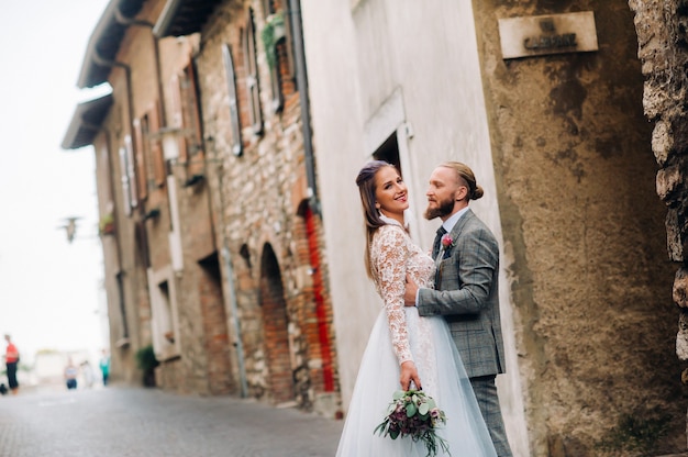 Hermosa familia con paseos en el casco antiguo de Sirmione en Italia.Una pareja paseando por la antigua Italia