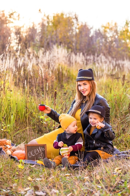 Hermosa familia con un perro golden retriever en un paseo en la naturaleza soleada de otoño