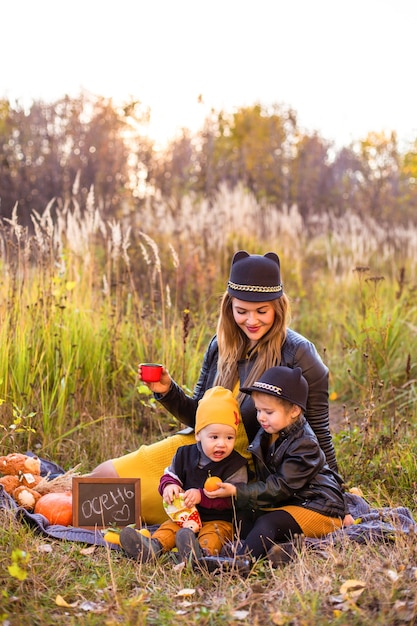 Hermosa familia con un perro golden retriever en un paseo en la naturaleza soleada de otoño